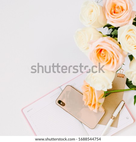 Blogging at home with beautiful roses and notebook with blank page on white background. Square picture