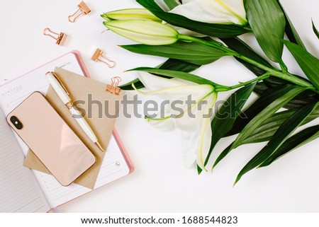 Beautiful fresh white lily and notebook with blank page on white background. Mood blogging concept