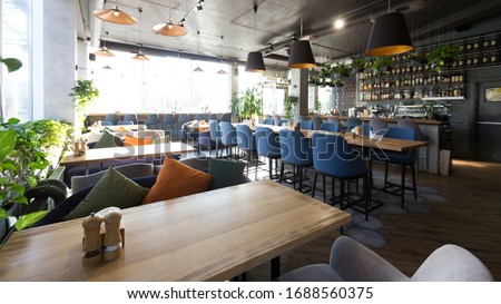 Cozy cafe interior with sofas and tables for quick lunch, angle view, panorama, copy space Royalty-Free Stock Photo #1688560375