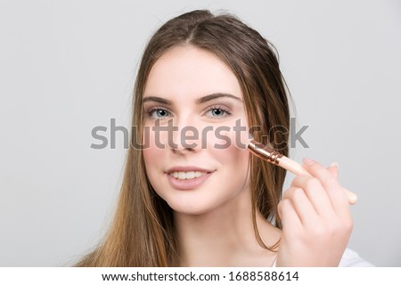 young woman / teenager is applying makeup for every day