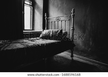 Vintage bed in empty bedroom. Black and white horizontal photo.