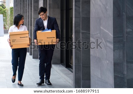 Male and female company employees are carrying their box out of the office because the company is closed or waste. Unemployed man, The economic downturn made people unemployed. Royalty-Free Stock Photo #1688597911
