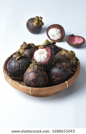 fresh mangosteen fruit.  in a bamboo basket .isolated on white background