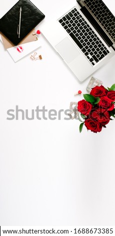 Vertical feminine work space of blogger with beautiful bouquet of roses and opened notebook on white background. Mood and blogging concept. 
