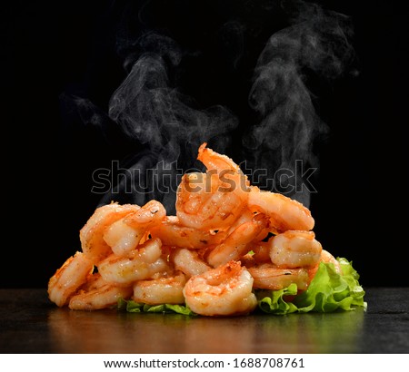Hot and spicy sweet and sour prawns shrimp with steam smoke on black background Royalty-Free Stock Photo #1688708761