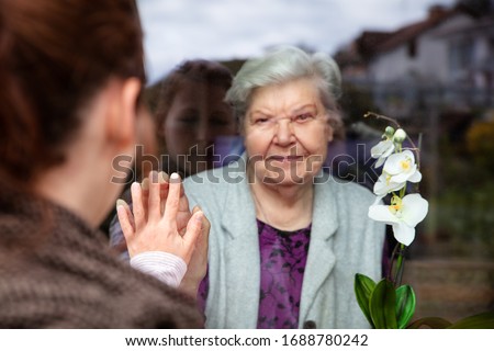 Social distancing among the family, grandma and grandchild on a window plane, concept coronavirus and covid-19 pandemic Royalty-Free Stock Photo #1688780242