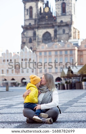 In profile, a mother and daughter in empty old town square in Prague. Czech Republic