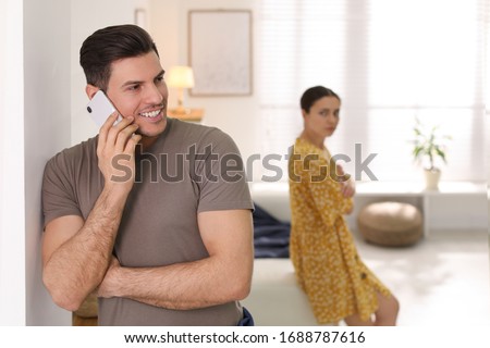 Man preferring talking on phone over spending time with his girlfriend at home. Jealousy in relationship Royalty-Free Stock Photo #1688787616