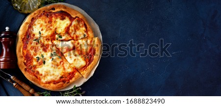 Top view of delicious and crispy vegetarian pizza Margherita on dark blue background