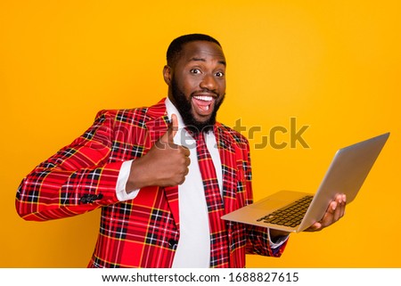 Photo of attractive dark skin business guy hold notebook raise thumb finger approve good wifi speed quality wear plaid red costume blazer shirt tie isolated yellow color background