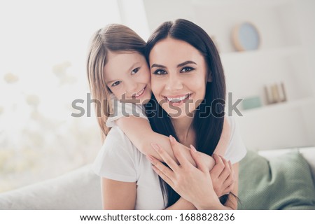 Closeup photo of cute small girl young charming mommy hugging holding each other close piggyback sitting comfy sofa spend free time together home house indoors