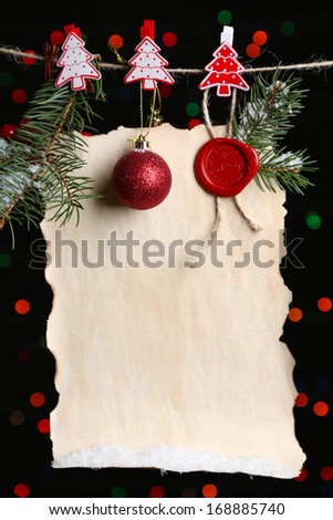 Blank sheet with Christmas decor on black background with lights