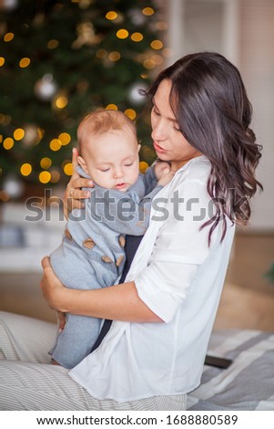 mom hugs her newborn son at home