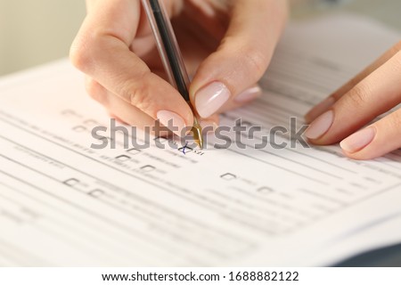 Close up of woman hands filling form crossing yes checkbox on a desk Royalty-Free Stock Photo #1688882122