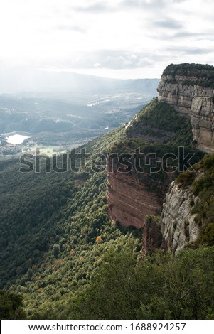 Vertical face mountain over the valley.
It is a partly cloudy autumn day in Rupit i Pruit, Catalunya, Spain, Europe.