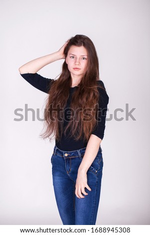 Close up portrait of a young beautiful brunette model isolated on gray background