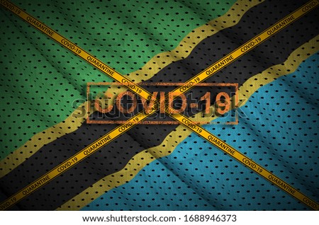 Tanzania flag and Covid-19 stamp with orange quarantine border tape cross. Coronavirus or 2019-nCov virus concept