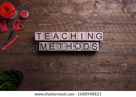 Word teaching methods in wooden cubes, blocks on the subject of education, development and training on a wooden background. Top view. Place for text