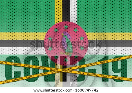 Dominica flag and Covid-19 inscription with orange quarantine border tape. Coronavirus or 2019-nCov virus concept