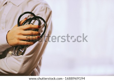 doctor with a stethoscope on hospital background. A doctor in a white coat with a stethoscope. coronavirus treatment. A doctor in a white coat holds a stethoscope in his hands.vintage photo processing