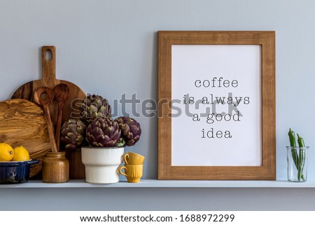 Modern composition on the kitchen interior with mock up photo frame, wooden cutting board, vegetables and kitchen accessories in stylish home decor.