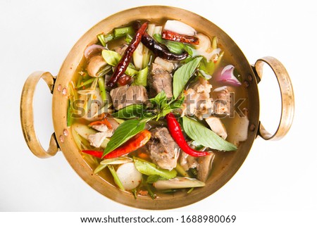 pork rips hot and spicy soup serve in brass pan isolated top view Royalty-Free Stock Photo #1688980069