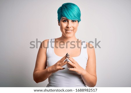 Young beautiful woman with blue fashion hair wearing casual t-shirt over white background Hands together and fingers crossed smiling relaxed and cheerful. Success and optimistic