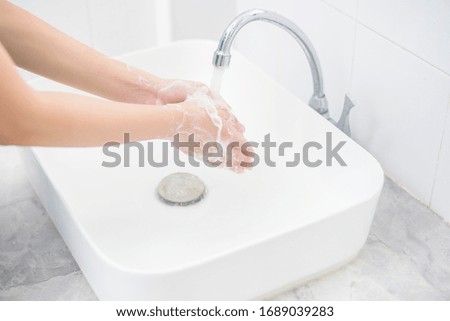 A woman is washing hands 