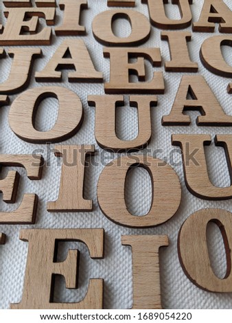 white surface covered in messy alphabet letters made of wood