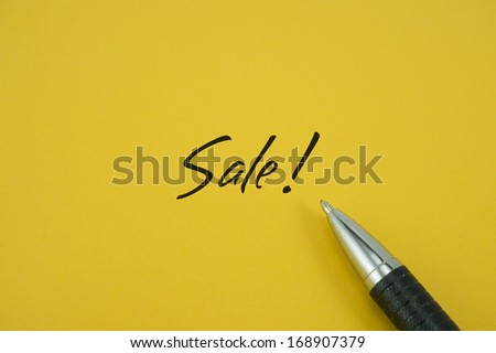 Sale note with pen on yellow background