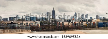 Downtown Atlanta Skyline showing several prominent buildings, apartments and hotels under a cloudy sky.