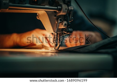 Sewing machine and men's hands of a tailor Royalty-Free Stock Photo #1689096199