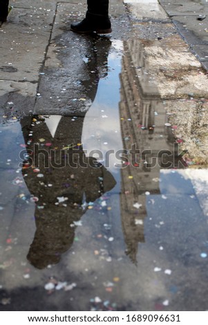 photo taken in lucca, reflection of a monument in a puddle of water with a girl in silhouette