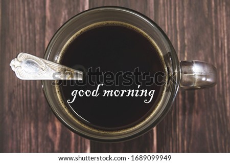 cup of black tasty coffee folded on a wooden background. View from above. The inscription good morning. Image is tinted.