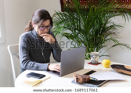 Young woman freelancer tele working on her computer at home during quarantine Royalty-Free Stock Photo #1689117061