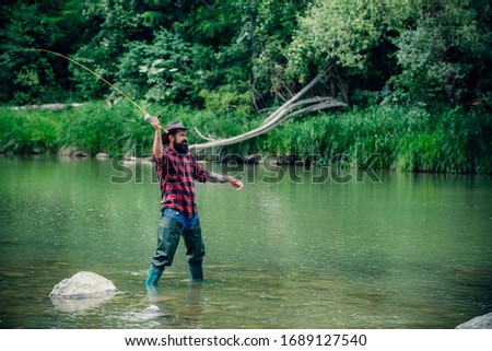 Elegant bearded brutal hipster man fishing. Fish on hook. Catch me if you can. Nice day for fishing. Keep calm and fish on. Fisherman with fishing rod. Handsome fisherman