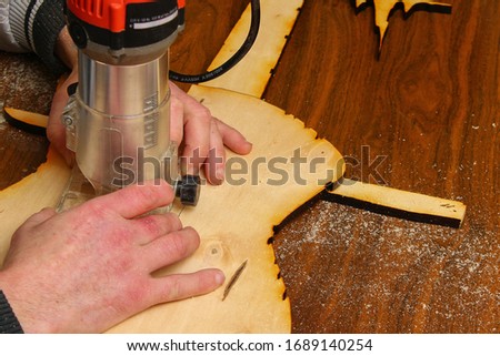 The process of wood milling by hand milling. An unusual hobby of carving wood. Toned background