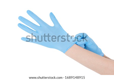 Individual protection products vinyl disposable gloves in the spread of virus and protection against infections. Women is dressing her hands in gloves. The coronavirus protection trend is COVID-19. Royalty-Free Stock Photo #1689148915