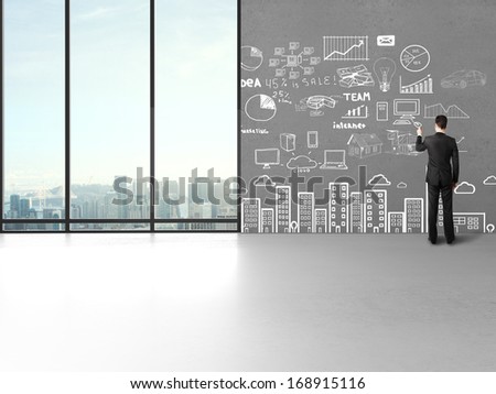 man drawing business concept on wall in office