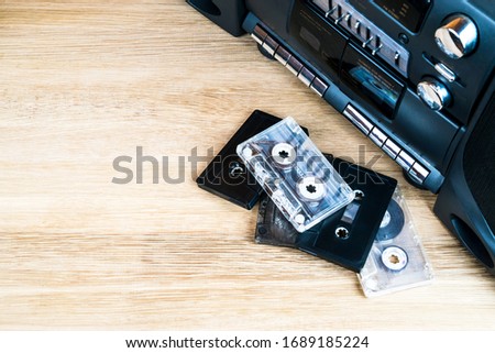 Old audio cassettes and a player on a wooden table
