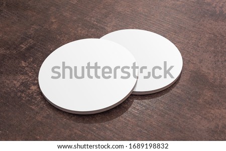Round white blank drink coasters lying on the wooden table. Mock Up. Circular beer mat to protect the surface of a table. Royalty-Free Stock Photo #1689198832