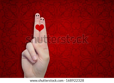Concept or conceptual human or female hands with two fingers painted with a red heart over a old vintage paper background for valentine romantic love couple young family or wedding