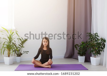 Quarantine at home. little girl do yoga during self isolation quarantine