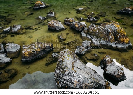 
Moss-covered stones in water, Iceland