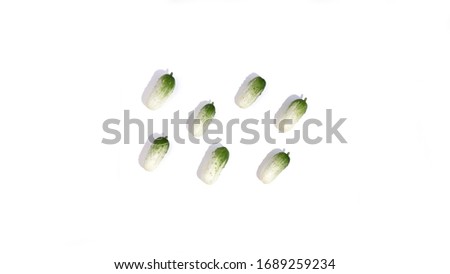 Small green cucumbers pattern with shadow isolated on white background. Natural healthy foodon table. Eco vegetable concept for market. Stock photo.