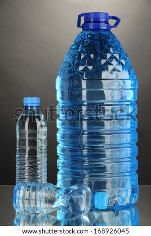Different water bottles on grey background