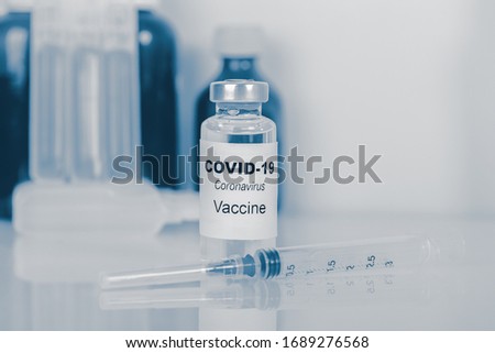 Coronavirus vaccine - The medical concept. Ampoule and syringe. Copyspace. blue toning. Royalty-Free Stock Photo #1689276568