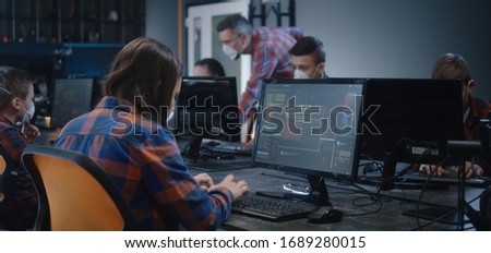 Medium shot of a girl in face mask learning programming in school