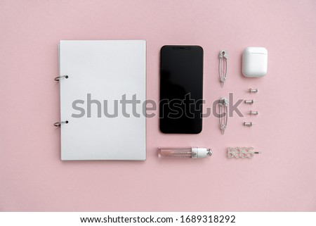 Office workspace top view on a pastel pink background, white notebook. The concept of study, business, education. Blog background, negative space. Iphone flat lay. 