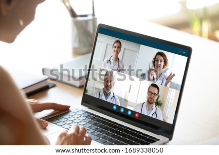 Close up of young female talk on video call consult with diverse doctors colleagues, woman patient have online consultation with GP or physicians, medical nurse in Webcam conference with coworkers Royalty-Free Stock Photo #1689338050